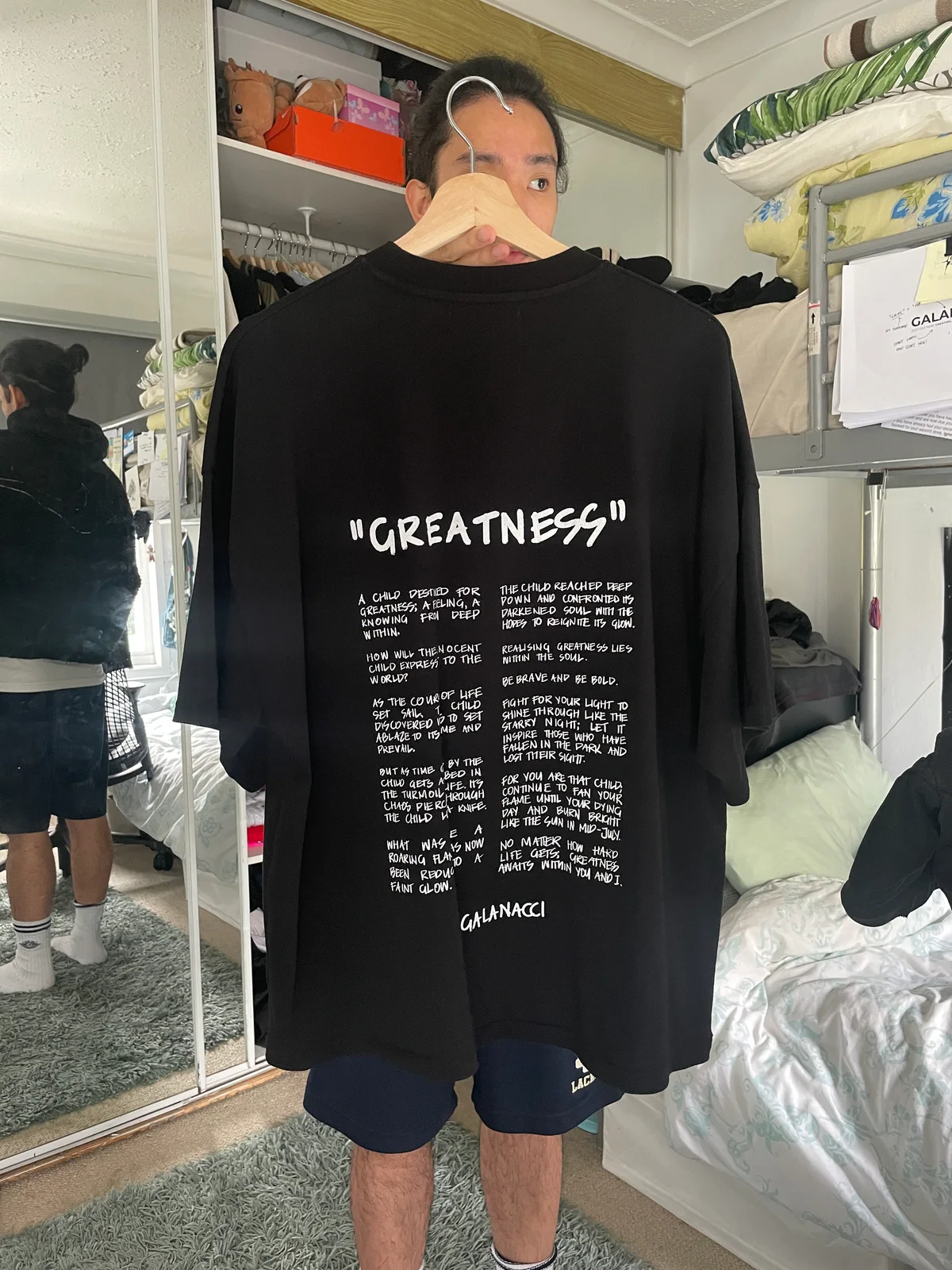 GALANACCI holding the first PIONEERS OF GREATNESS product, the GREATNESS tee